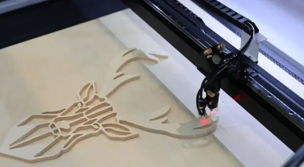 Favism3D: Regalos y decoración de madera personalizados con corte láser de alta precisión. Máquina de corte láser de madera creando un diseño artístico de cabeza de ciervo personalizado.
