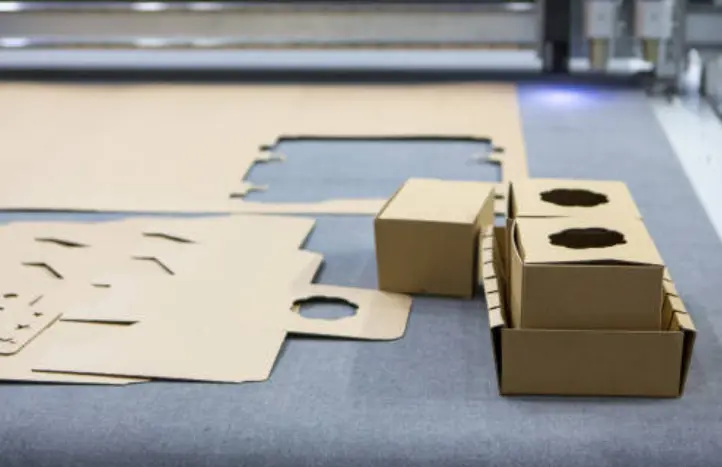 Favism3D: Soluciones de corte y grabado láser en cartón para packaging y decoración de eventos personalizados. Corte láser de cartón: Máquina creando packaging personalizado y elementos decorativos para eventos con alta precisión.
